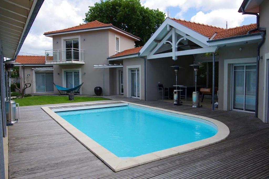 a swimming pool in front of a house at Villa Marie Suzon - Belle propriété pour 16 personnes à 5 mn de la Hume in Gujan-Mestras