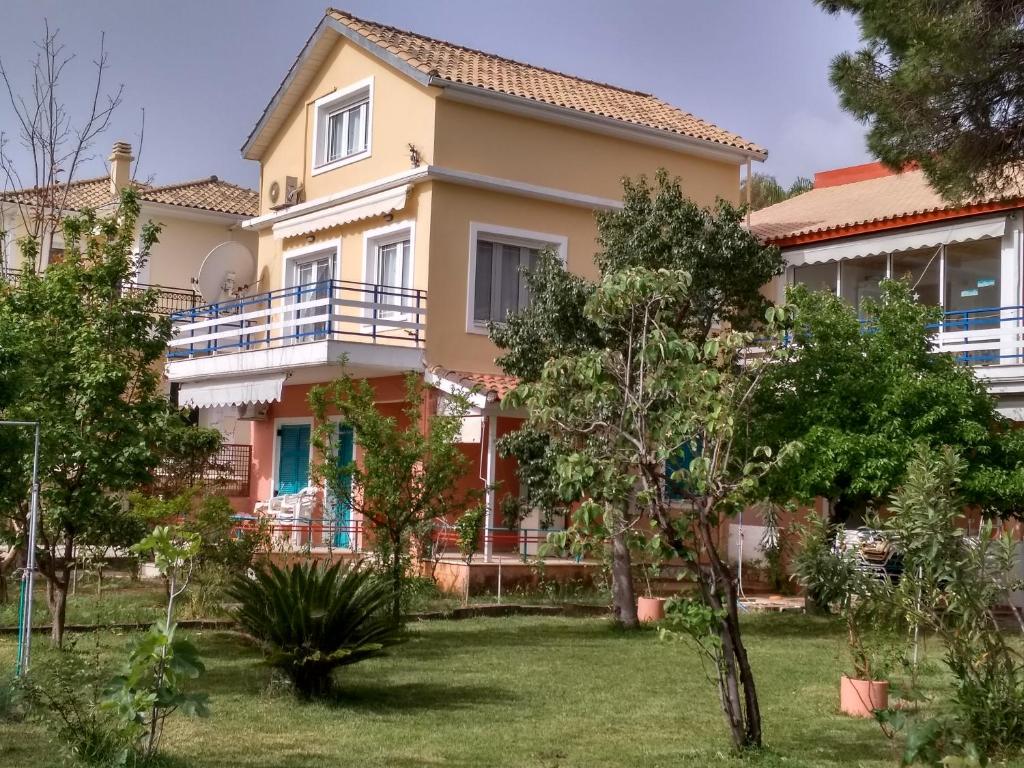 a house with a garden in front of it at Palmyra Beachfront Studios in Nydri