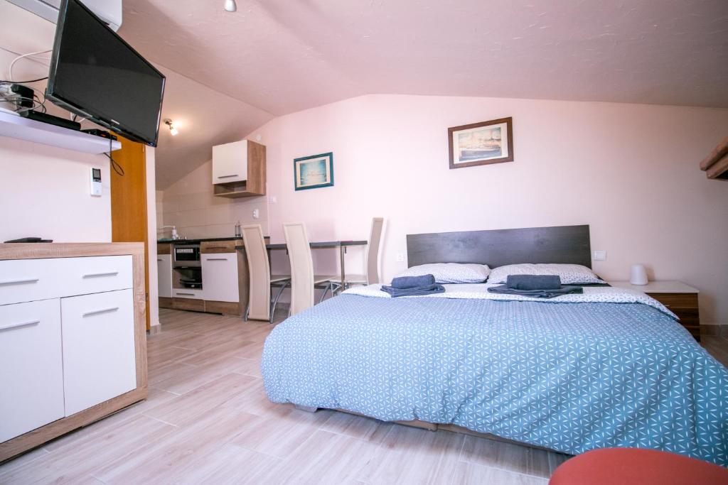a bedroom with a large bed and a kitchen at Apartment Jug in Piran