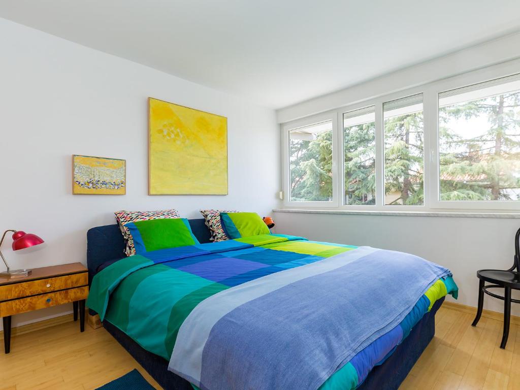 a bedroom with a bed with a blue and green comforter at Apartment Pical in Poreč