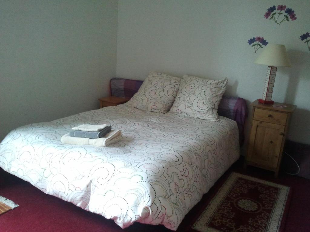 1 dormitorio con 1 cama con edredón blanco en Pacéenne, en Pacé