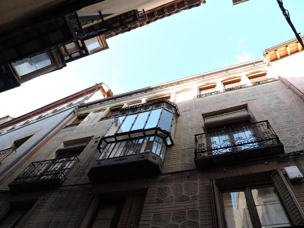 a tall brick building with windows and balconies at El Ático del Nuncio in Toledo