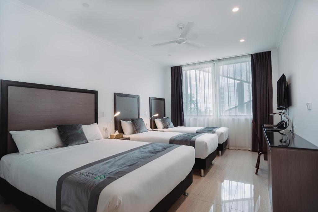 Ένα ή περισσότερα κρεβάτια σε δωμάτιο στο Darwin City Hotel