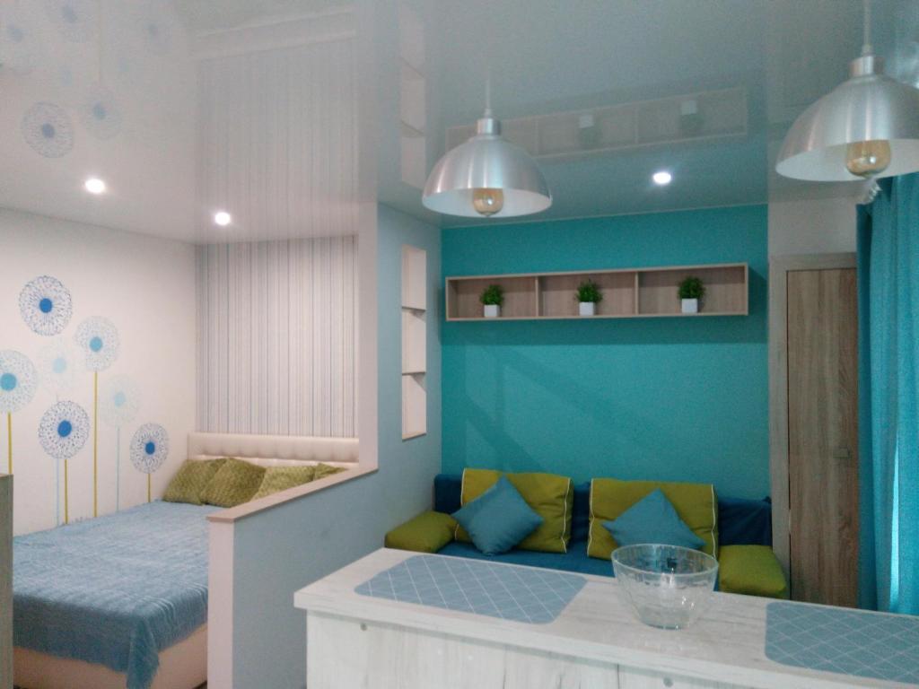 フメリヌィーツィクィイにあるквартира-студия в центреのベッド1台とソファが備わる小さな客室です。