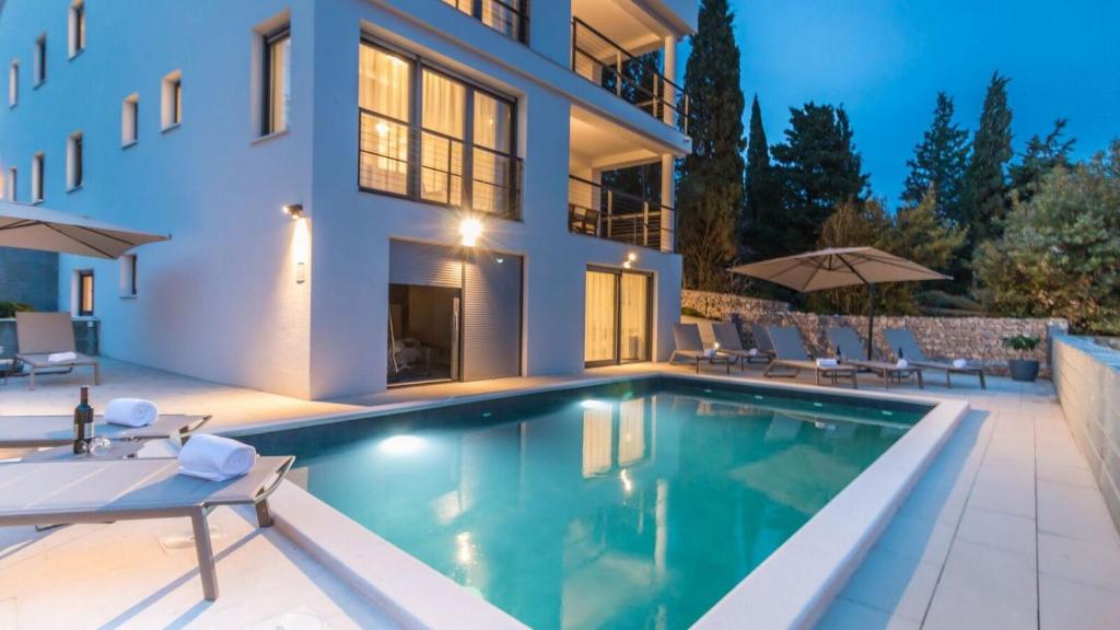 a villa with a swimming pool at night at Apartment Di Blu in Novi Vinodolski