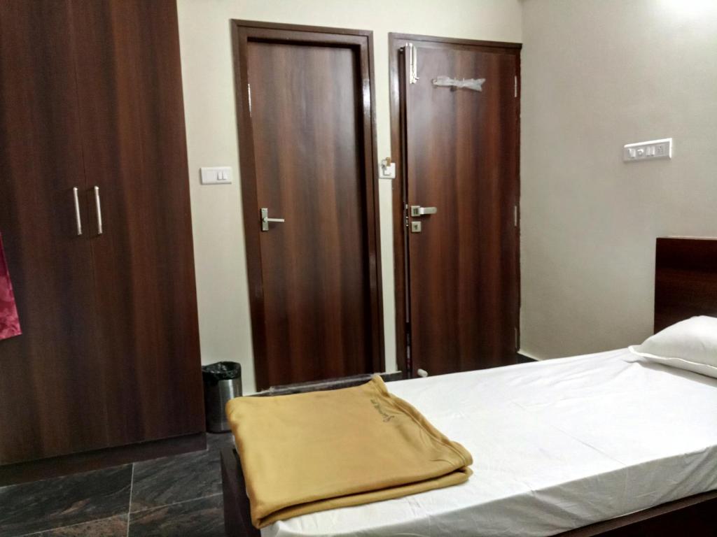 een slaapkamer met een bed en een aantal houten kasten bij Sapphire stay in Bangalore