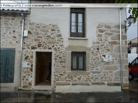 a stone building with a door and two windows at Casa Rural La Antigua Fragua in Los Llanos de Tormes