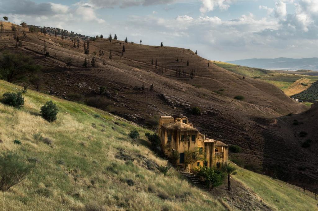 un vieux bâtiment sur le côté d'une colline dans l'établissement Beit Al Fannan, à Ţabaqat Faḩl