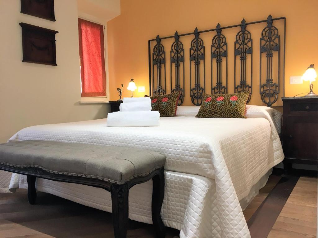 een slaapkamer met een groot wit bed en een bank bij Emilia's Home in Siena