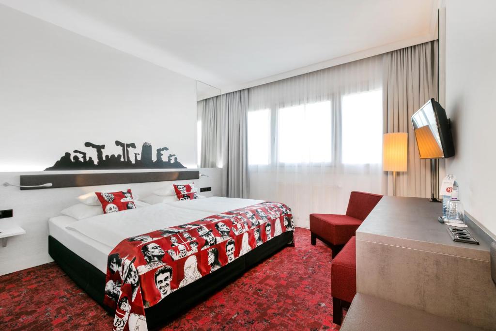 a hotel room with a bed and a red carpet at ARCOTEL Nike Linz in Linz