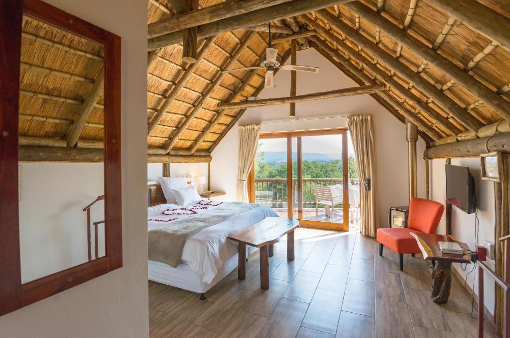 a bedroom with a bed and a room with a window at Amadwala Lodge in Roodepoort