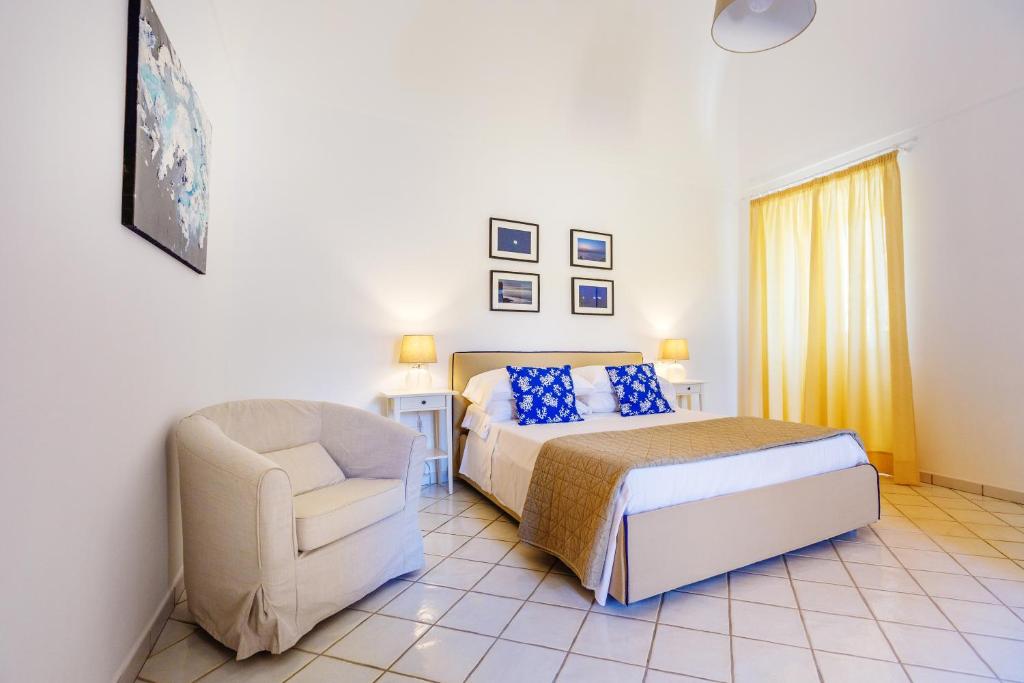 a bedroom with a bed and a chair at Casa Assunta B&B in Vico Equense