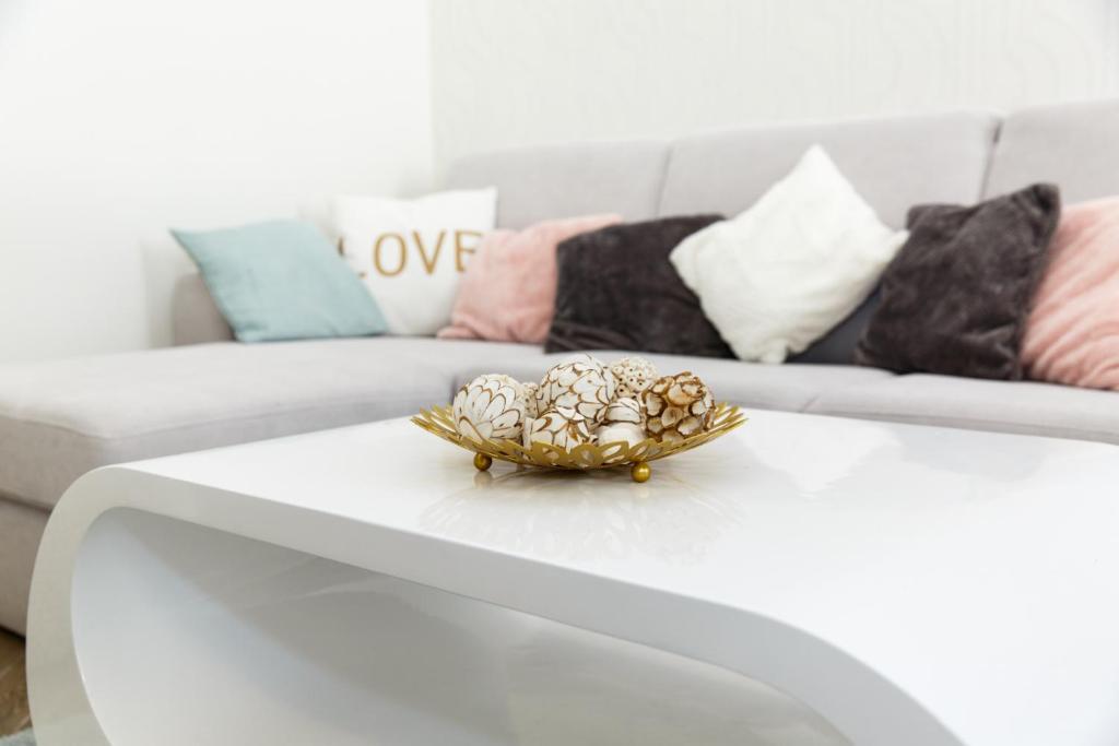 a bowl on a white coffee table with a couch at Jenny luxury two bedrooms apartment. in Budapest