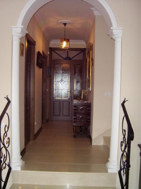 an archway leading to a hallway with a door at El Palacete in Setenil