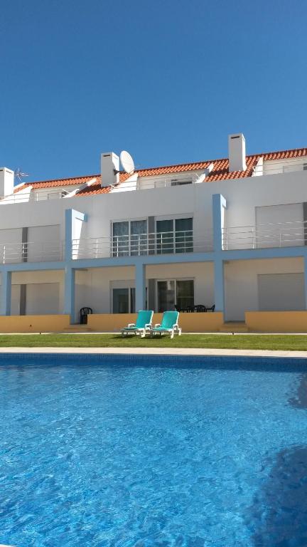 ein Haus mit einem Pool vor einem Gebäude in der Unterkunft Townhous Praia da Areia Branca in Praia da Areia Branca