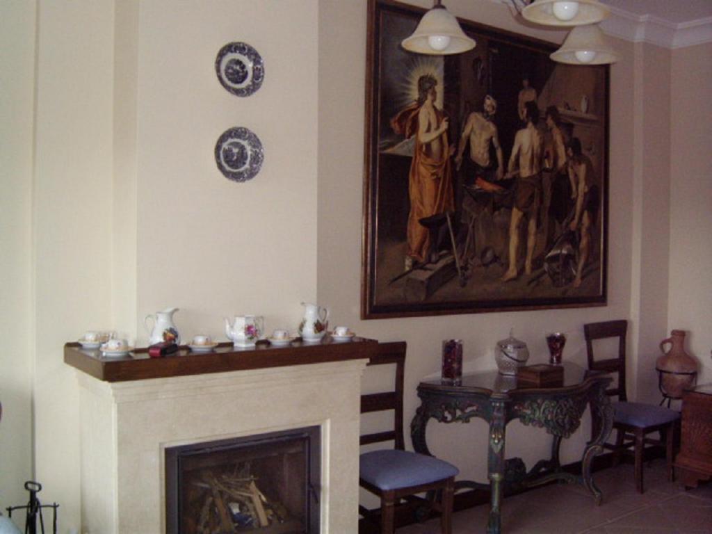 a living room with a fireplace and a painting on the wall at El Palacete in Setenil