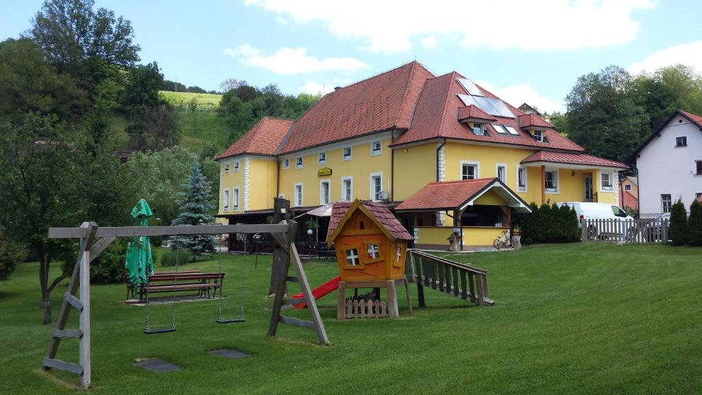 una casa con parque infantil frente a una casa en Guest House Čater, en Laško