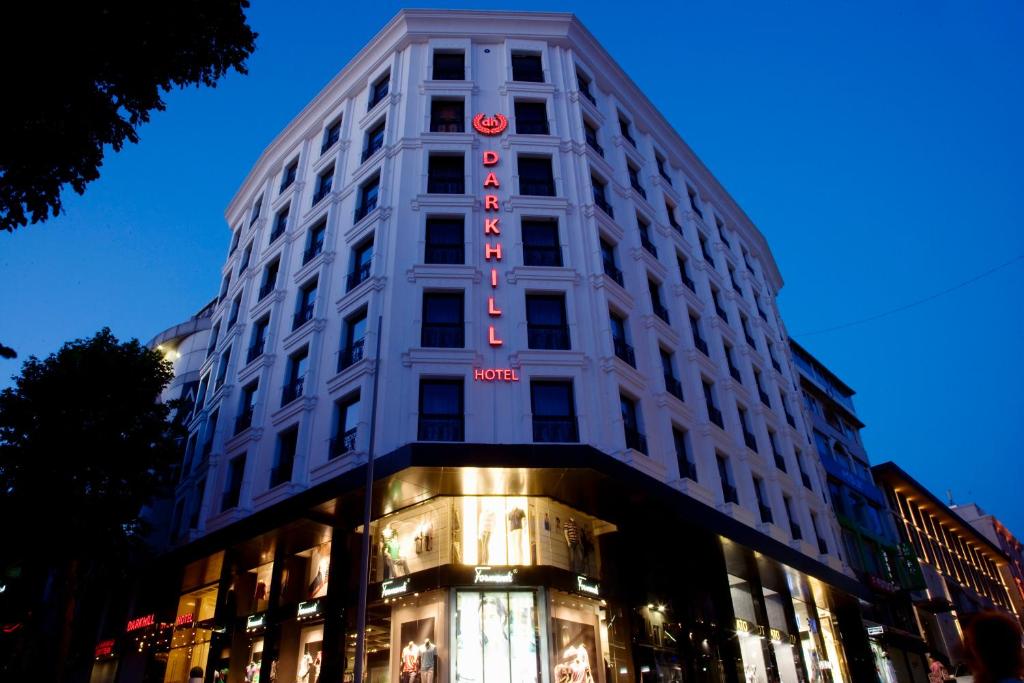 un edificio blanco alto con un letrero rojo. en Darkhill Hotel, en Estambul