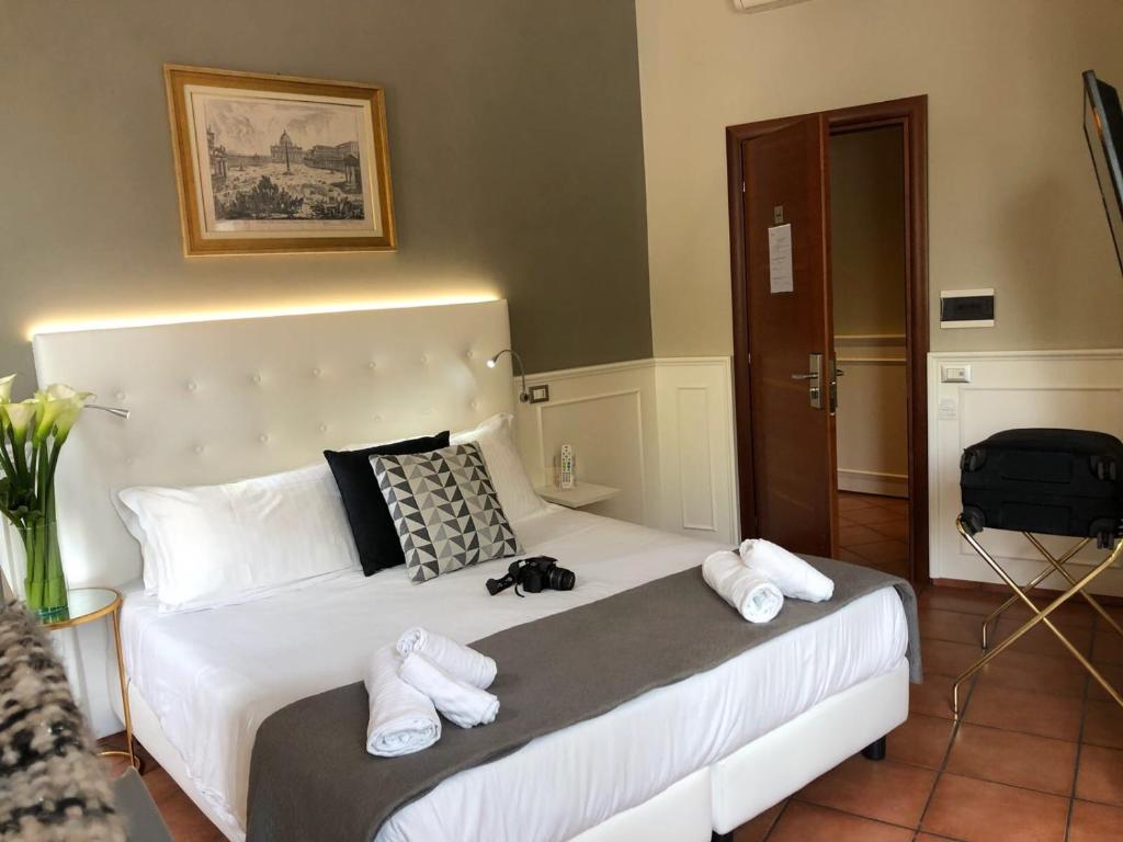 a bedroom with a white bed with towels on it at 207 Inn in Rome