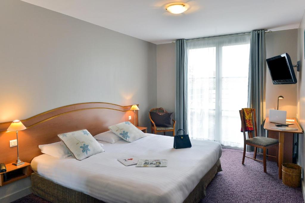 een hotelkamer met een groot bed en een raam bij Soleil et Jardin in Solaize