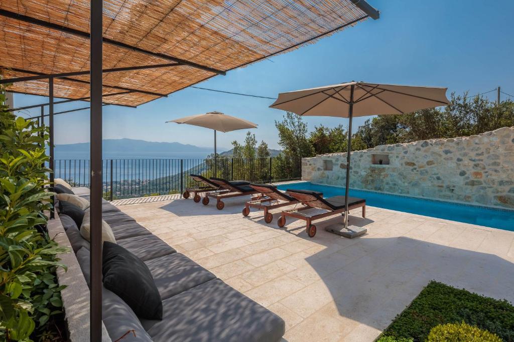 a patio with benches and umbrellas and a swimming pool at Villa Mara in Zaostrog