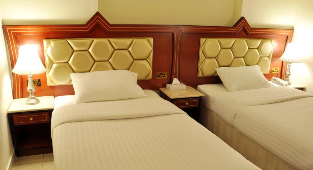 ein Hotelzimmer mit 2 Betten und 2 Lampen in der Unterkunft Saffron Hotel in Dubai
