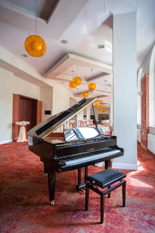 a piano sitting in a room with a table at Caro Hotel in Bucharest