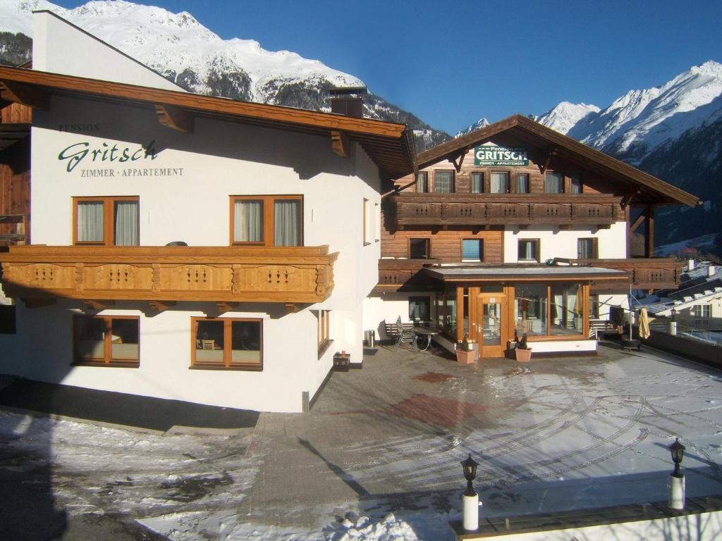 a building with a courtyard in front of a mountain at Haus Gritsch in Sölden