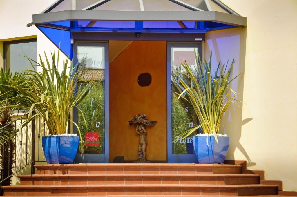 a house with blue pots on the stairs at Hotel Villa Rosa in Sirmione