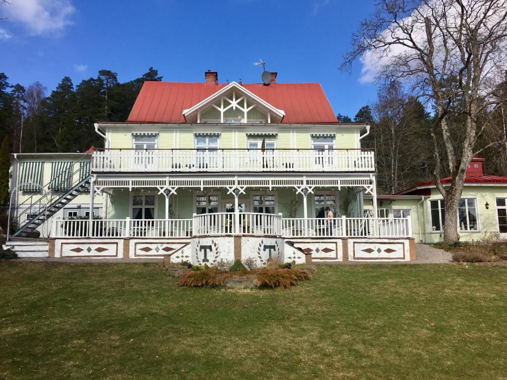 ein großes weißes Haus mit rotem Dach in der Unterkunft Hotell Torpa Pensionat - Sweden Hotels in Södertälje