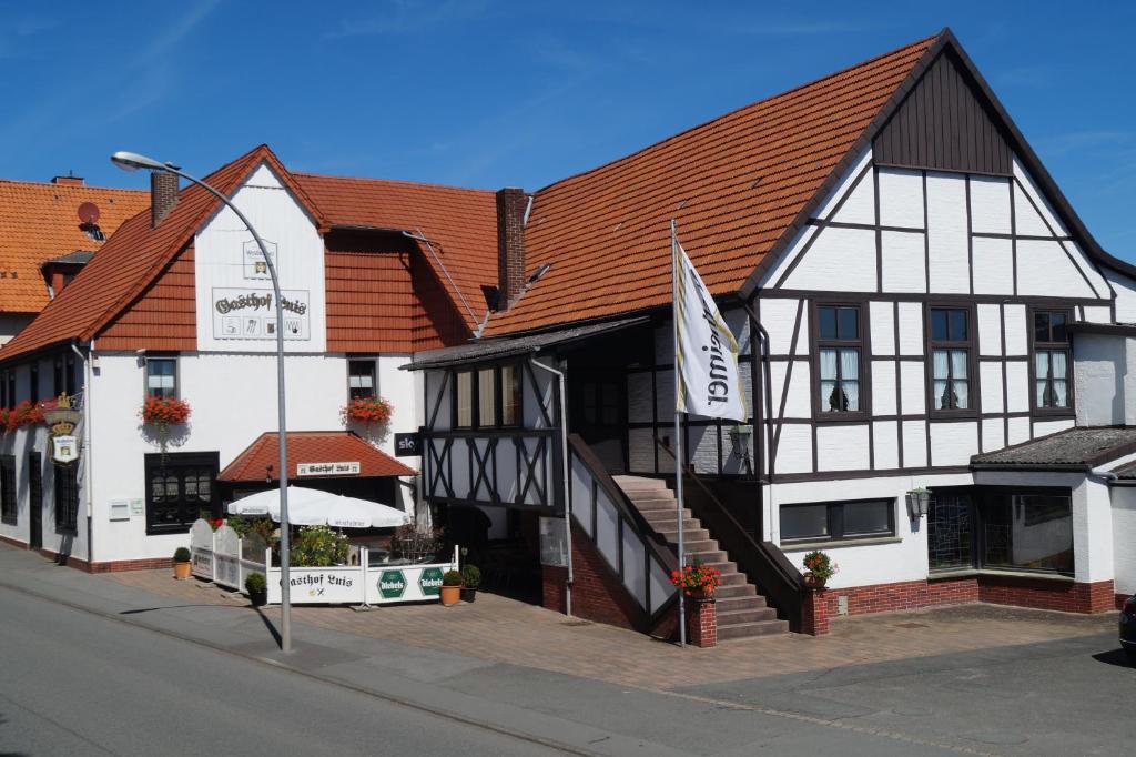 a large white and black building on a street at Hotel Gasthof Luis in Warburg