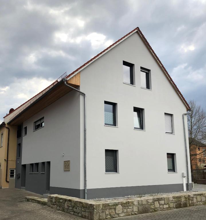 a white building with black windows on a street at Krug-Apartments in Ebelsbach