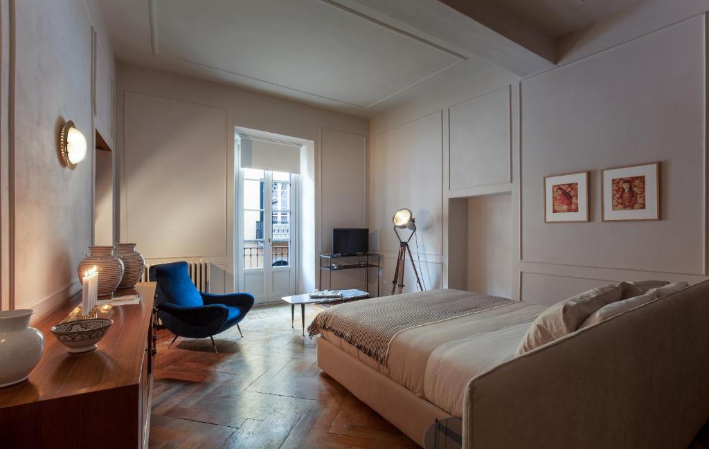 a bedroom with a bed and a desk and a chair at Suites Menaggio in Menaggio