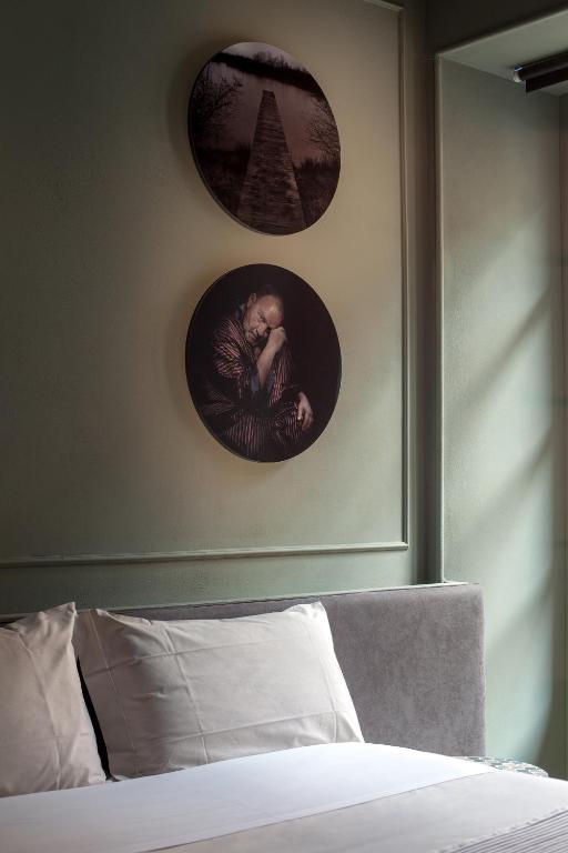 a bedroom with two pictures on the wall and a bed at Suites Menaggio in Menaggio