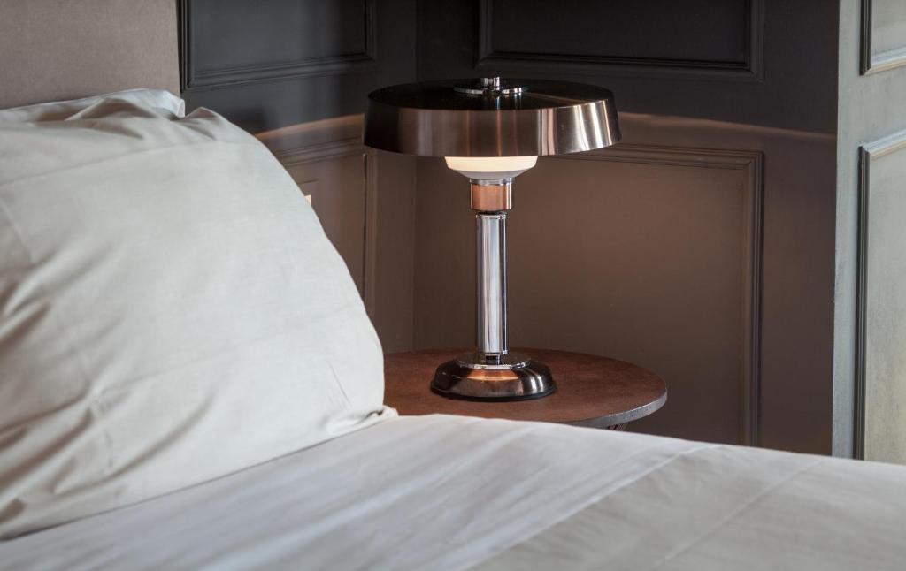 a lamp sitting on a table next to a bed at Suites Menaggio in Menaggio