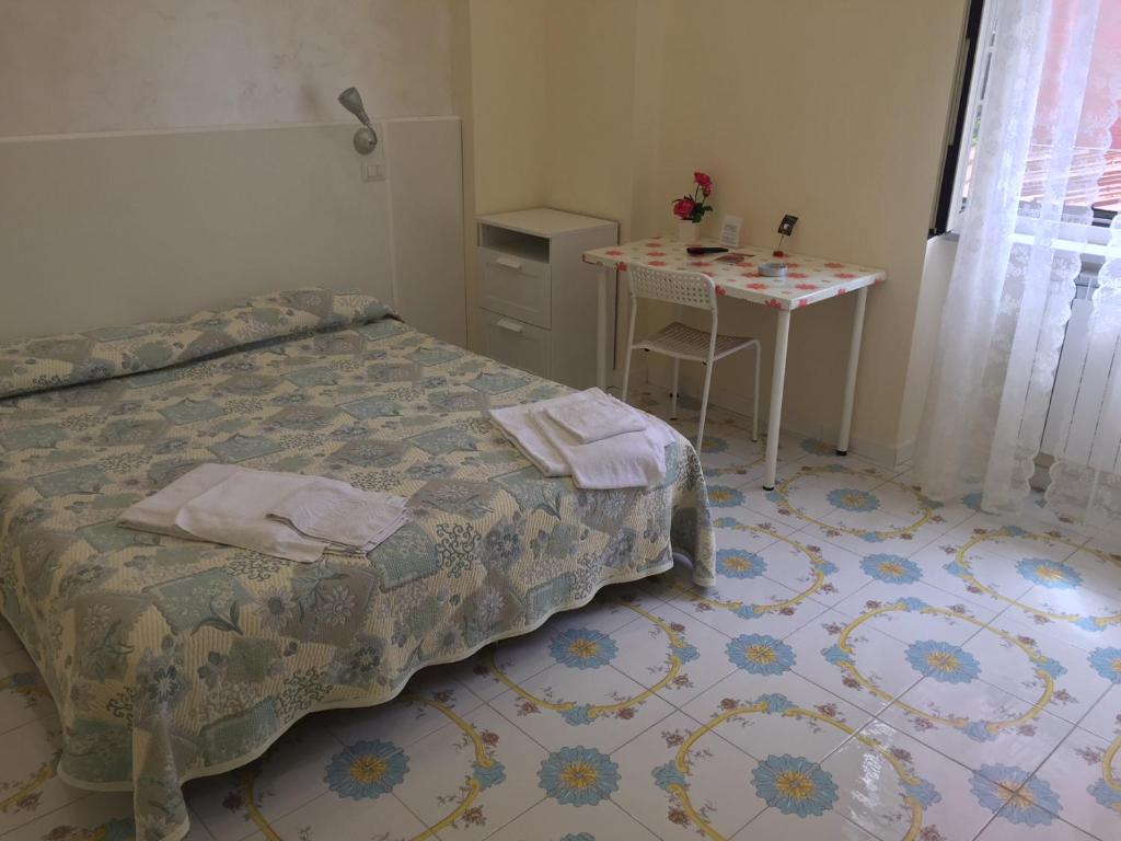 um quarto com uma cama e uma mesa em Albergo Oasi em Nápoles
