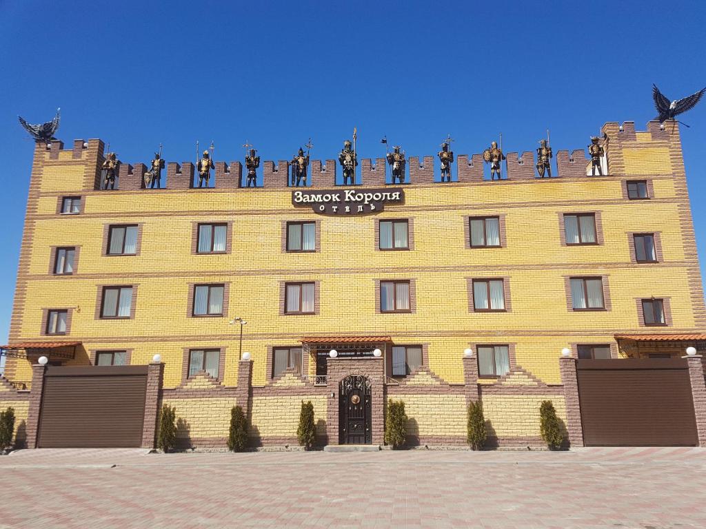 a large yellow building with people on top of it at Hotel Zamok Korolya in Voronezh