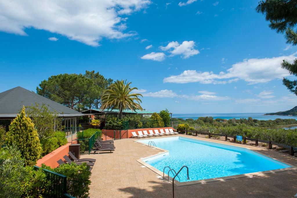 a swimming pool with a view of the ocean at Residence Castell'Verde in Porto-Vecchio