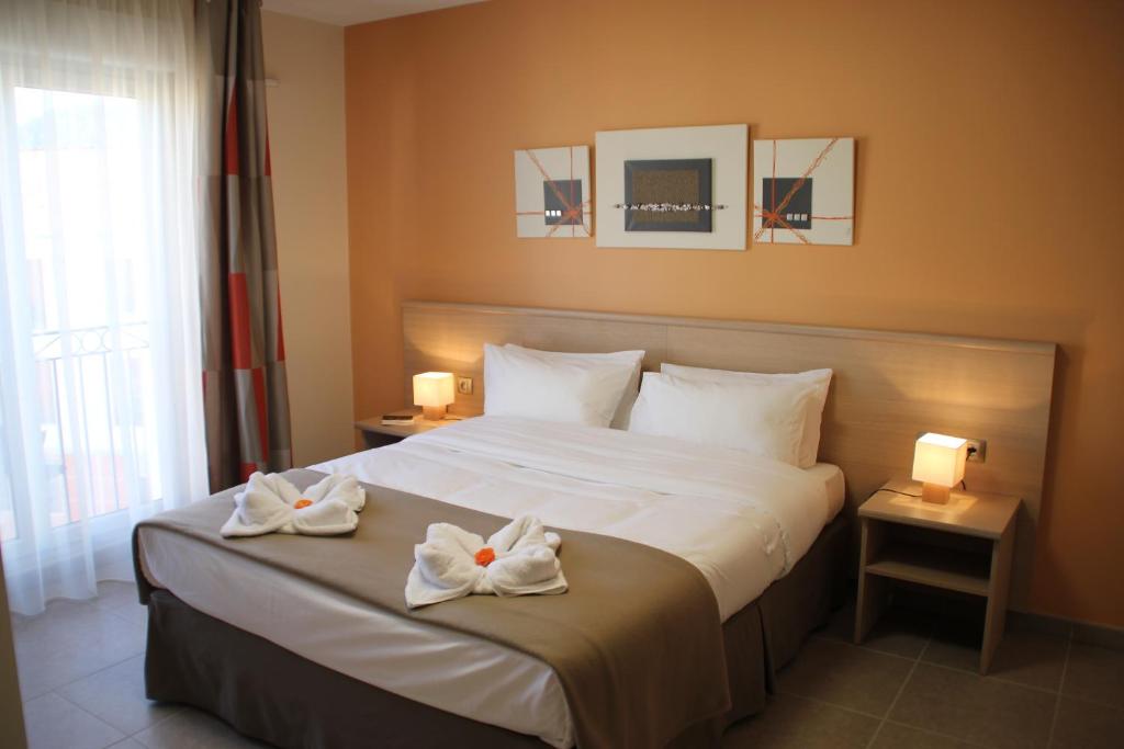 Una habitación de hotel con una cama con toallas. en The Originals Boutique, Hotel l'Occitan, Aubagne, en La Destrousse