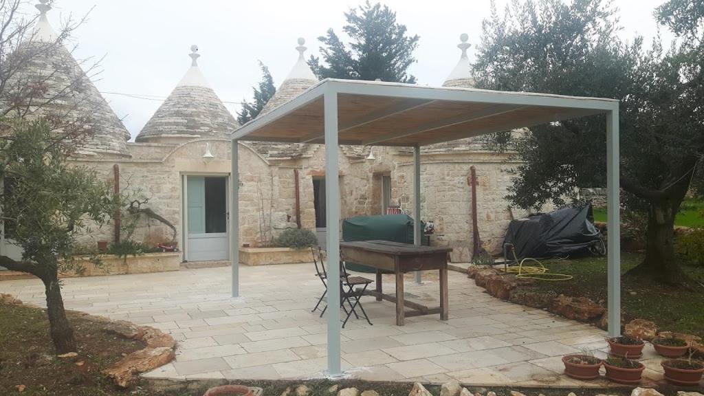 a pavilion with a table and a piano on a patio at Trulli Spinosa in Cisternino