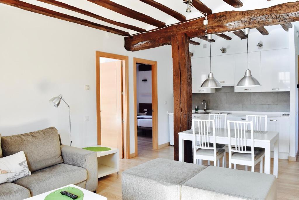 Apartamentos Turísticos Rincones del Vino في إيزكاراي: غرفة معيشة مع أريكة وطاولة