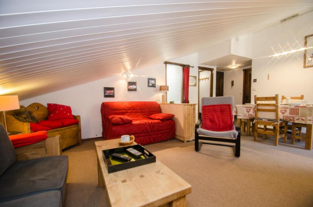 a living room with a red couch and a table at Petra in Chamonix