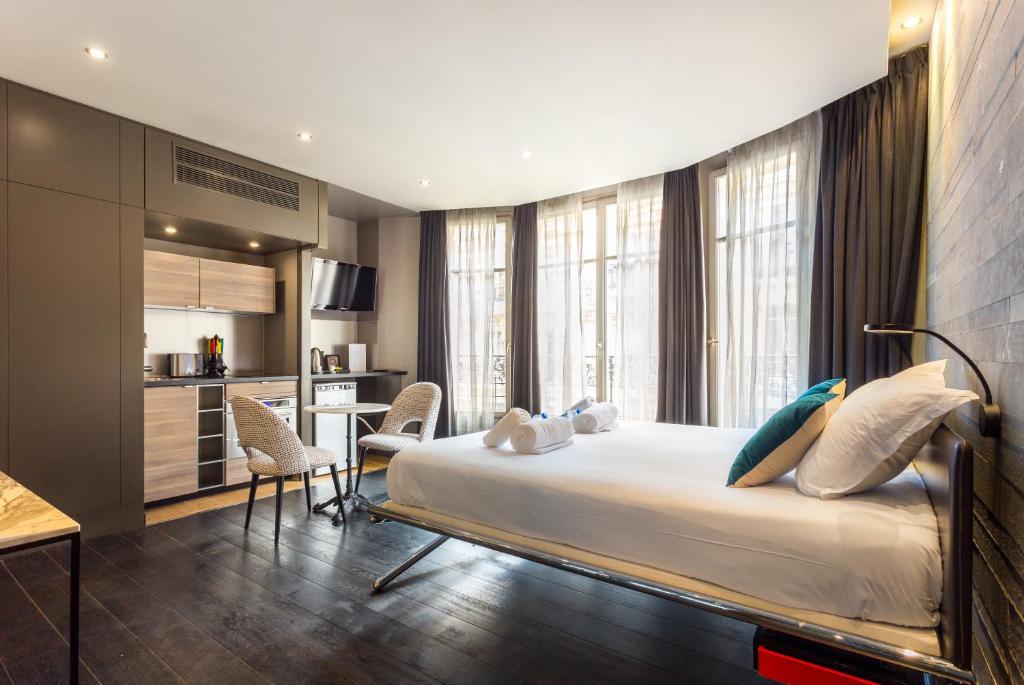 a bedroom with a large bed and a kitchen at CMG - Deluxe Tour Eiffel - 62 in Paris