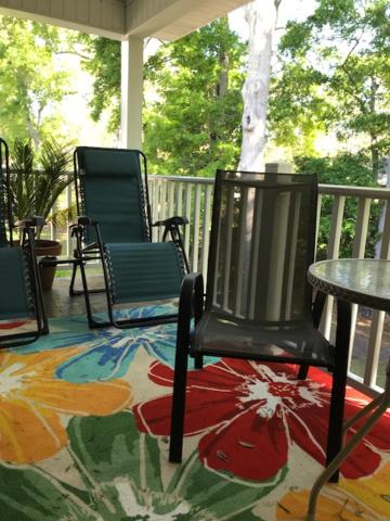 a porch with three chairs and a table on a patio at E12 Awesome renovation, comfy well stocked kitchen make some memories! in Saint Simons Island