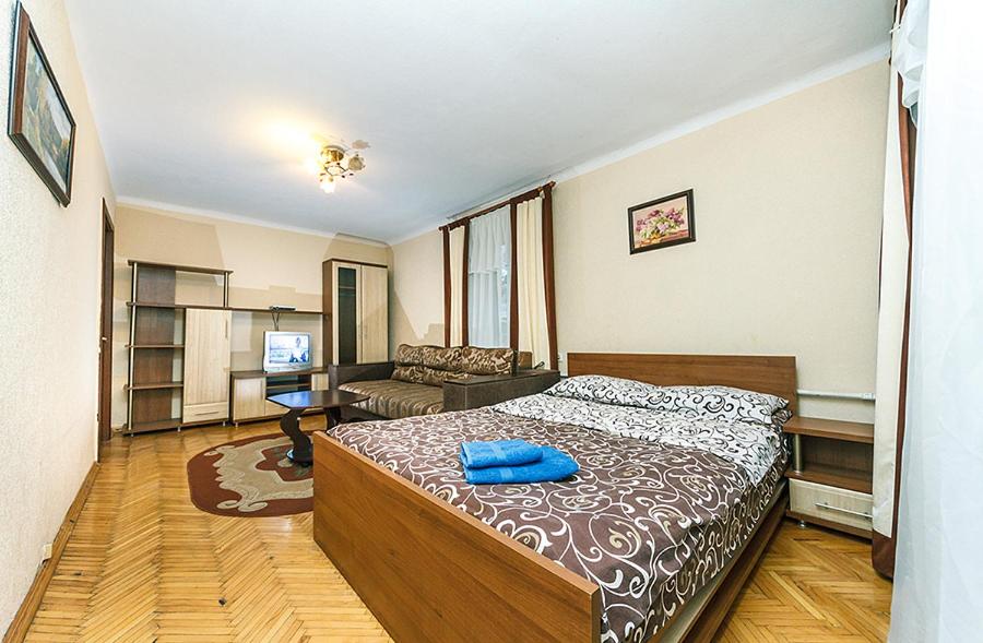 een slaapkamer met een bed met een blauw kussen erop bij ЦЕНТР,1К КВАРТИРА М.КЛОВСКАЯ in Kiev