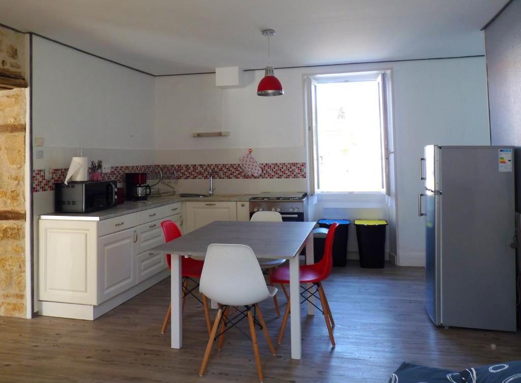 une cuisine avec une table, des chaises et un réfrigérateur dans l'établissement NAT-SEB 13 Avenue de Beaulieu, à Marennes