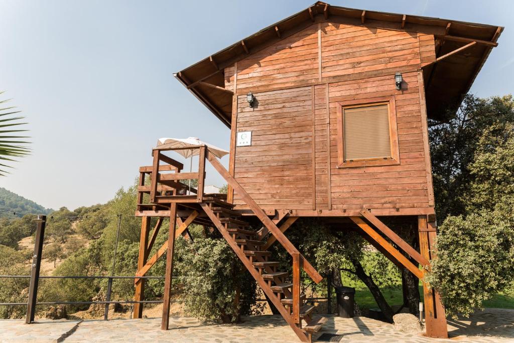 una casa en el árbol con escalera y escalera en Cabaña El Mirador, en Pedroso de Acim