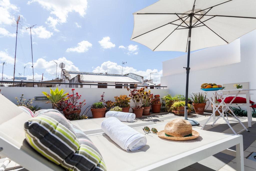 einen weißen Tisch mit einem Strohhut auf dem Balkon in der Unterkunft Sevilla Home Center in Sevilla