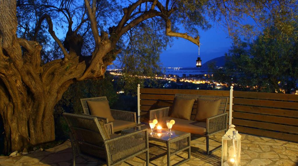 patio z 2 krzesłami, stołem i drzewem w obiekcie Liopetra w mieście Ligia