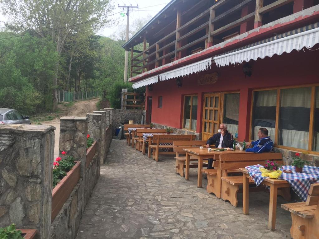 two people sitting at tables outside of a building at Kod Dace in Banja Topilo